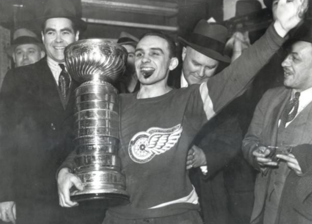 Herbie Lewis with the 1936 Stanley Cup. Bruce Norris & James Norris Sr. join him