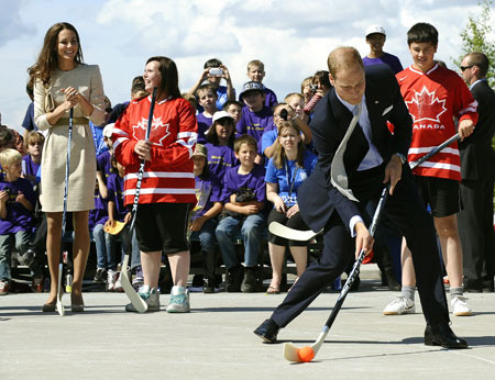 Prince William shoots a ball in street hockey,  Kate watching