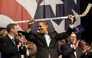 Barack Obama holds Ice Hockey stick above head