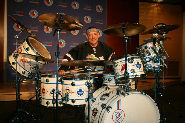 Neal Pearl of Rush with the Hockey Drum Set he Donated to HHOF