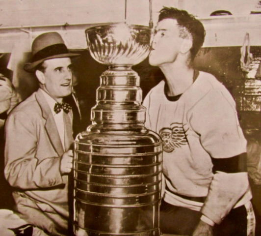 Detroit Red Wings Tommy Ivan watches Tony Leswick kiss the Stanley Cup bowl 1954